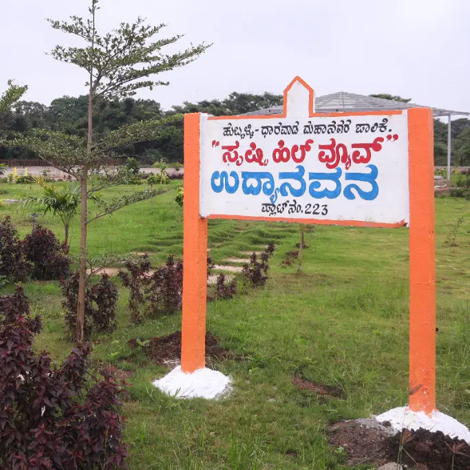 Landscaped green park with walking paths and kids play area at Shristi Hill View Hubli.