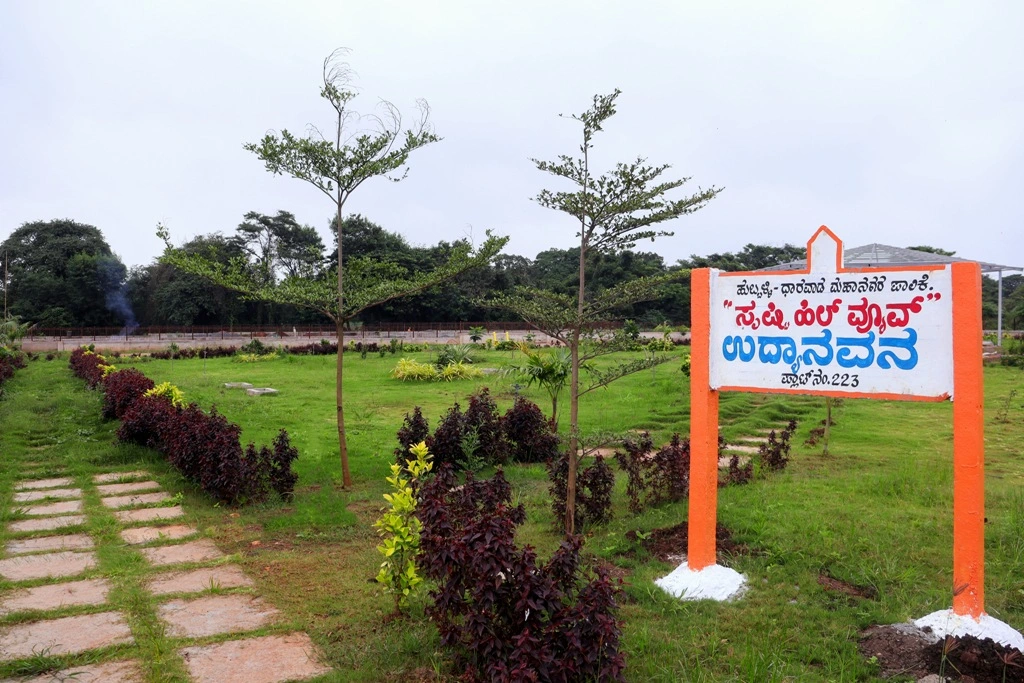 Landscaped green park with walking paths and kids play area at Shristi Hill View Hubli.