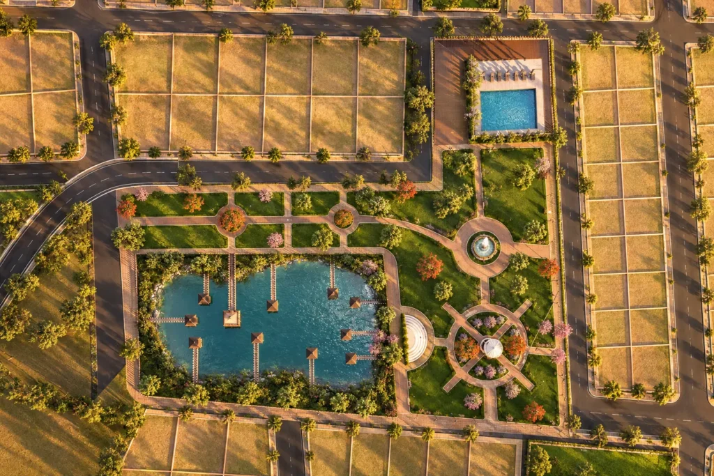 Top-down aerial 3D render of the 33-acre master plan layout at Shristi Lake Shore by Newgen Homes in Hubli, highlighting the central lake, swimming pool, parks, and residential plot grids.